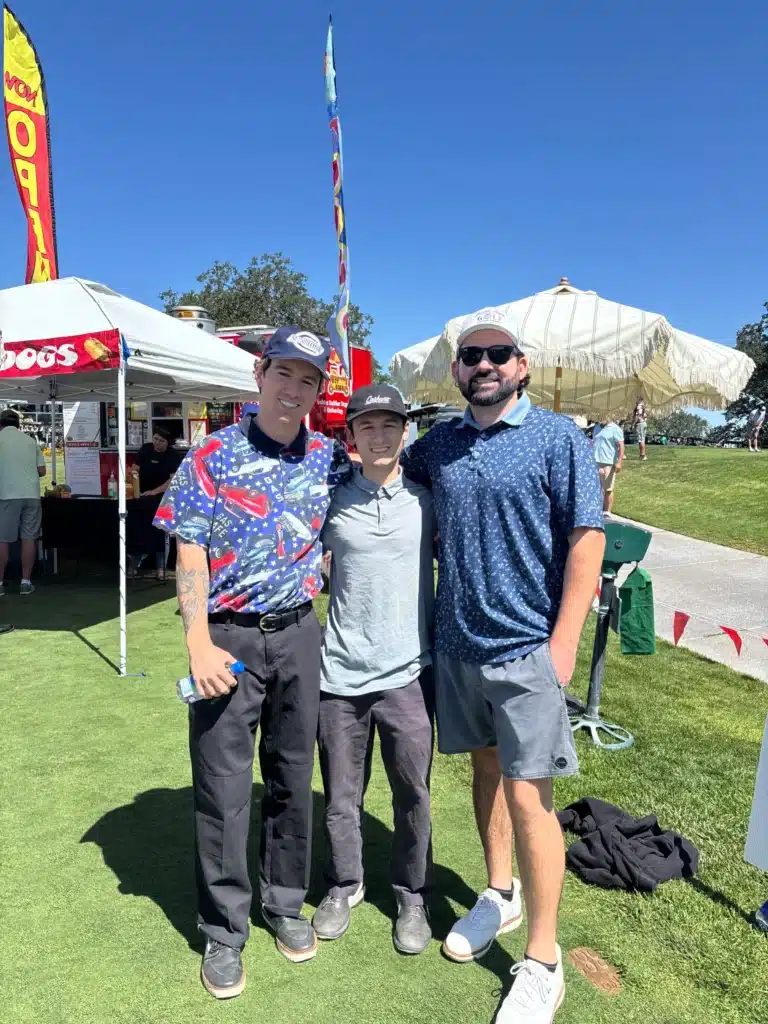 Three Clever Ducks team members standing together at an outdoor golf event