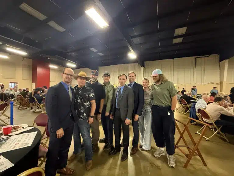 Seven Clever Ducks team members standing together at a community event in a hall